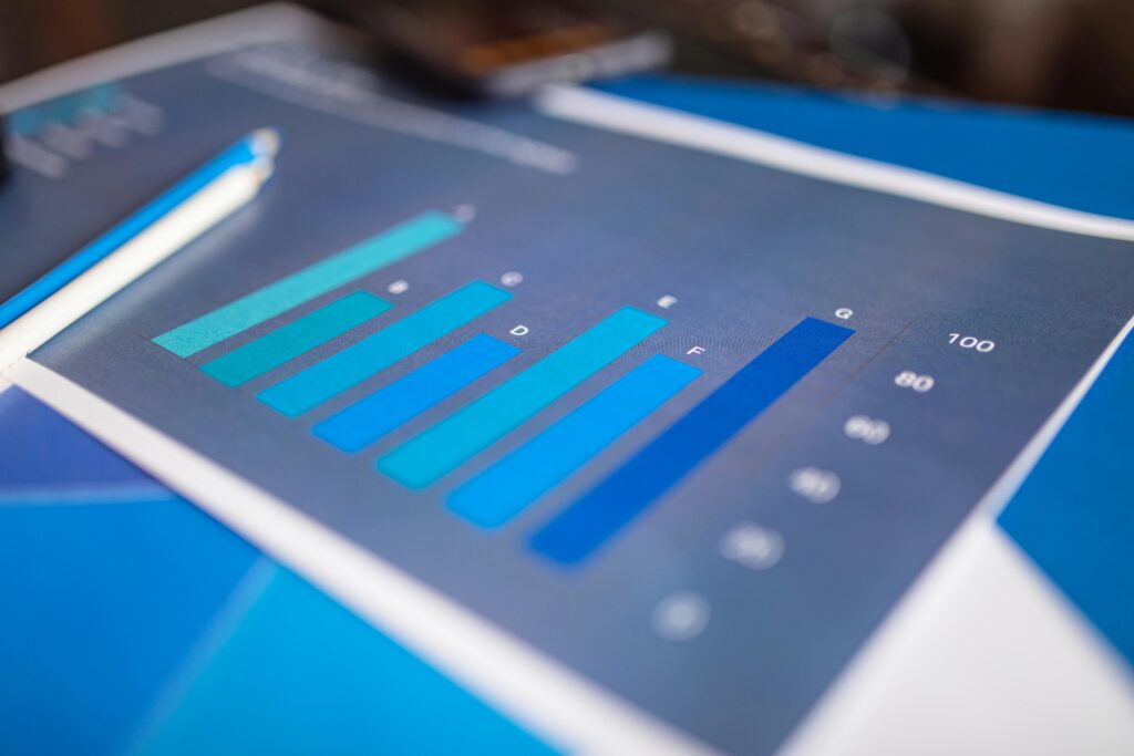 pexels photo 7947754 7947754 Detailed close-up of a blue bar graph showing data analysis on printed paper.